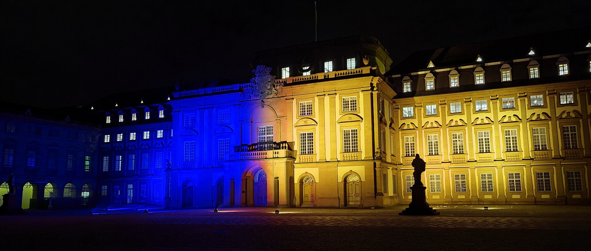 Das Schloss der Uni Mannheim leuchtet in den Farben der Ukraine: gelb und blau.