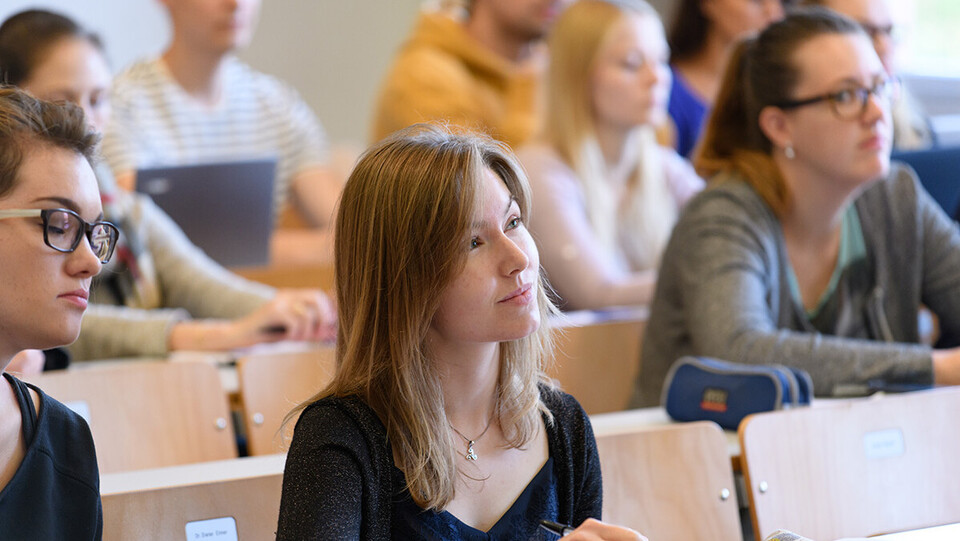 Zuhörerschaft im Lehrsaal, im Vordergrund sind zwei weibliche Studierende zu sehen