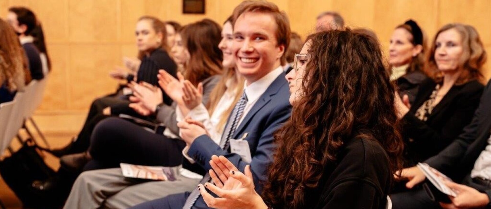 Gruppe von Menschen in der Aula aplaudierend 