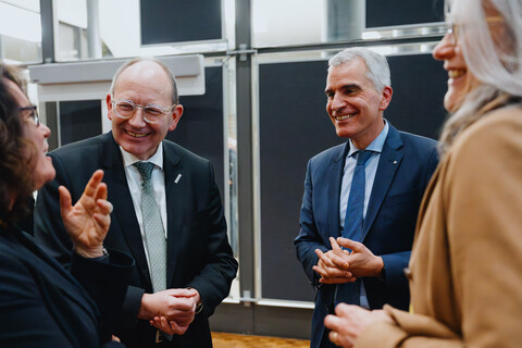 Das BIld zeigt vier fröhliche Menschen im Gespräch