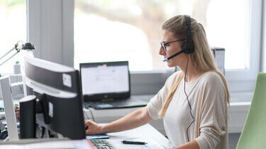 Person with headset sitting at computer