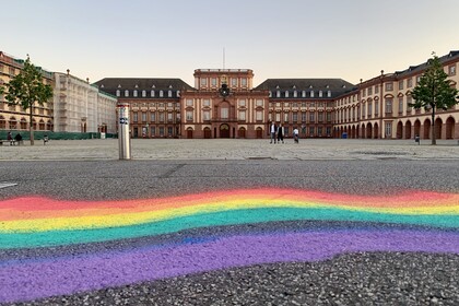 Ein Regebogen ist mit Kreide oder Sprühfarbe auf den Asphalt vor dem Ehrenhof gemalt.