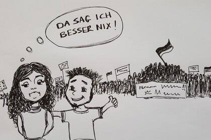 Ein Mädchen und ein Junge stehen vor einer mit Bannern und Flaggen protestierenden Menschenmenge. Der Junge sieht glücklich darüber aus und legt einen Arm um die Schulter des Mädchens. Dieses sieht nicht froh aus, in einer Denkblase steht "Da sag ich besser nichts".