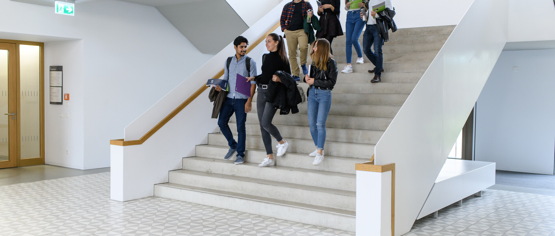 Studierende laufen die Treppen des B6 Gebäudes runter