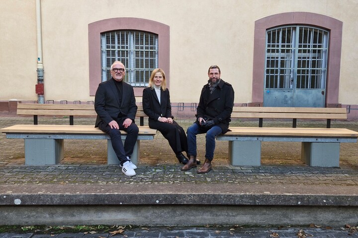Thomas Gleßner, Sabrina Scherbarth und Christian Haas sitzen auf den neuen Sitzbänken im Schneckenhof. 