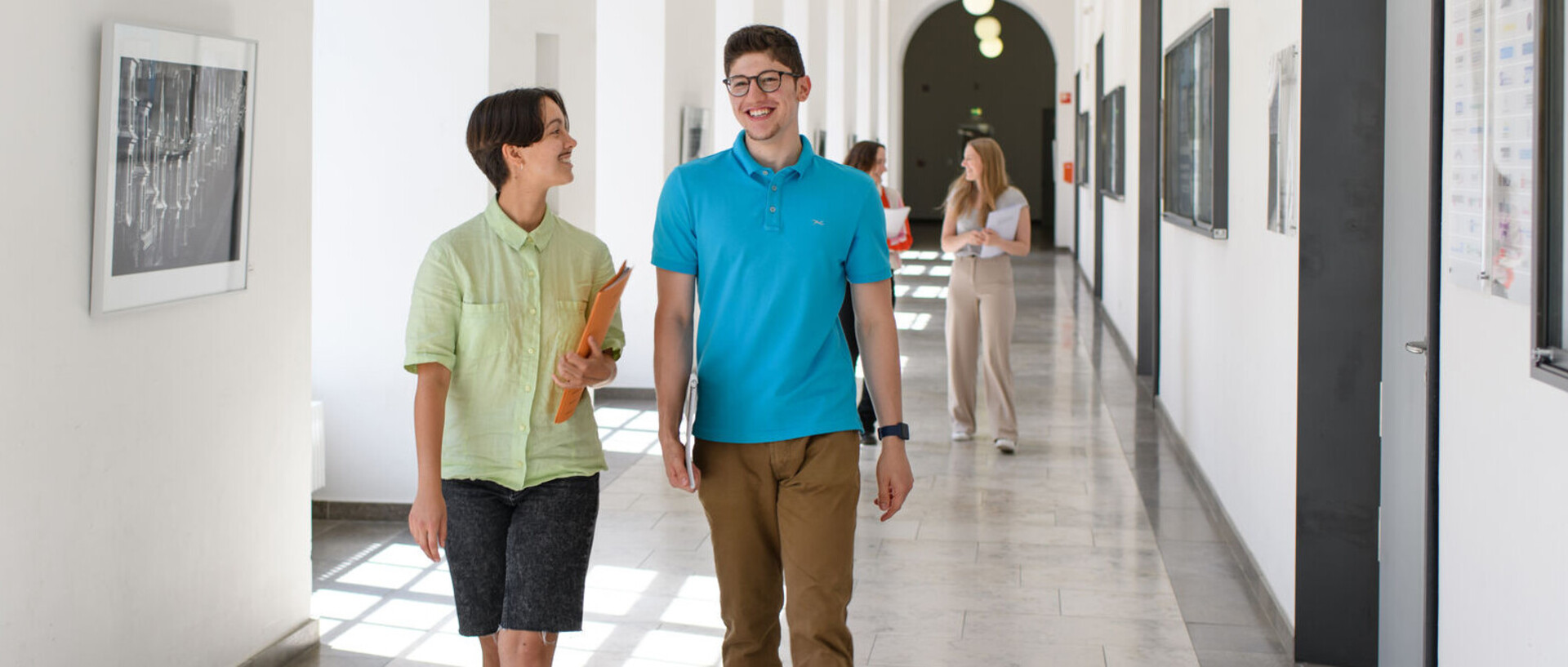 Vier Studierende laufen im Seminartrakt des Schlosses und lachen. Link: Alle Infos zur Bachelor-Bewerbung