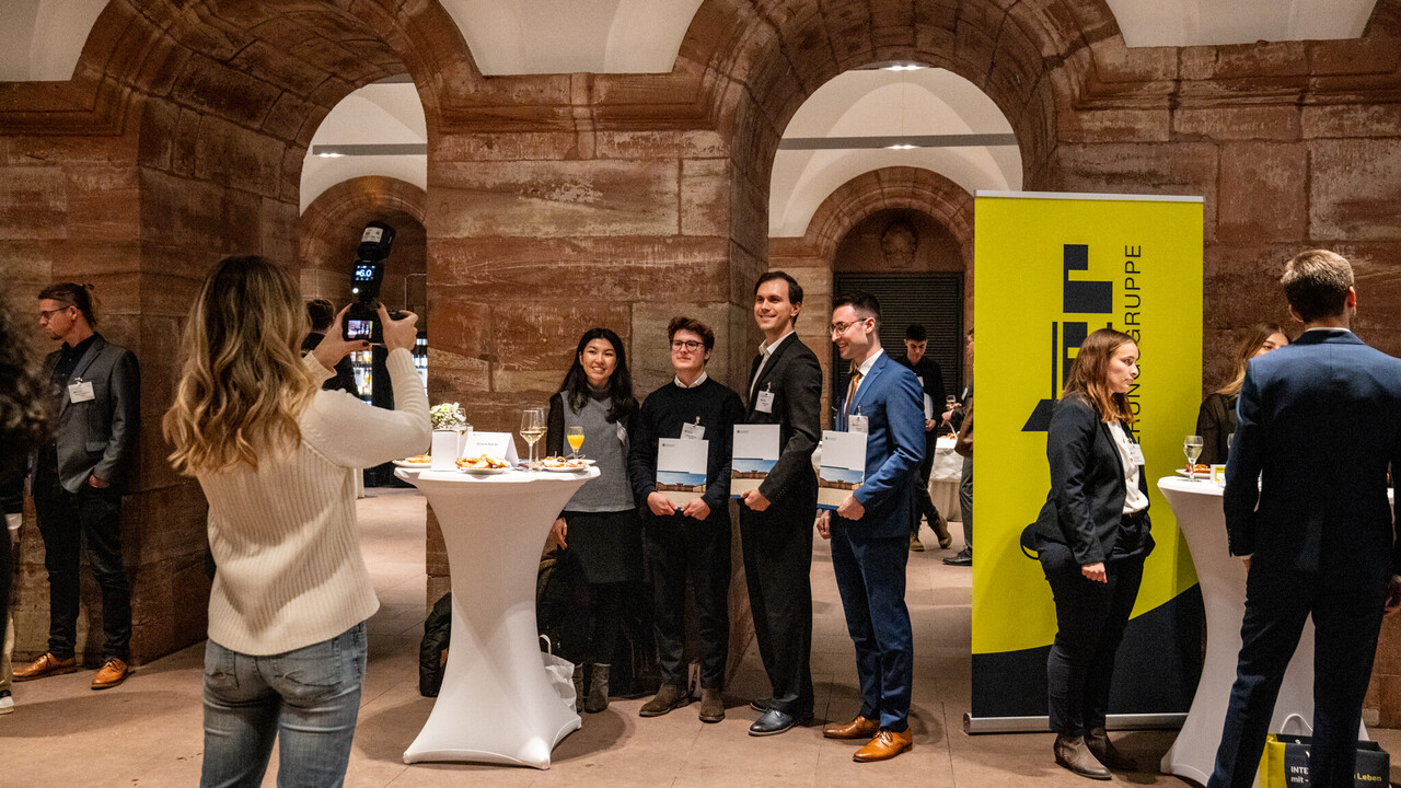 Eine Person fotografiert vier Personen, die Urkunden in den Händen halten