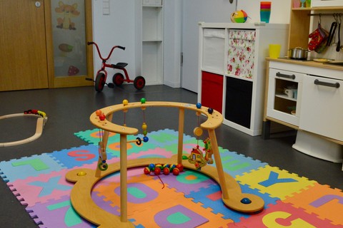 Elter-Kind-Zimmer der Universität Mannheim. Bunte Spielsachen liegen auf dem Boden.