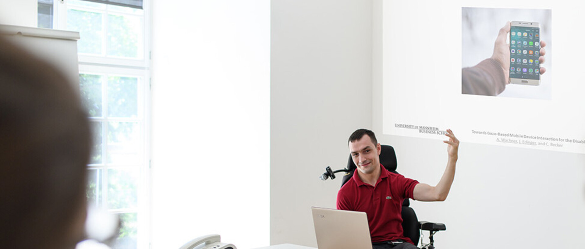 A student in a wheelchair gives a lecture with a PowerPoint presentation