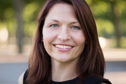 Portrait von Prof. Sabine Carey im Freien vor grünem Hintergrund.