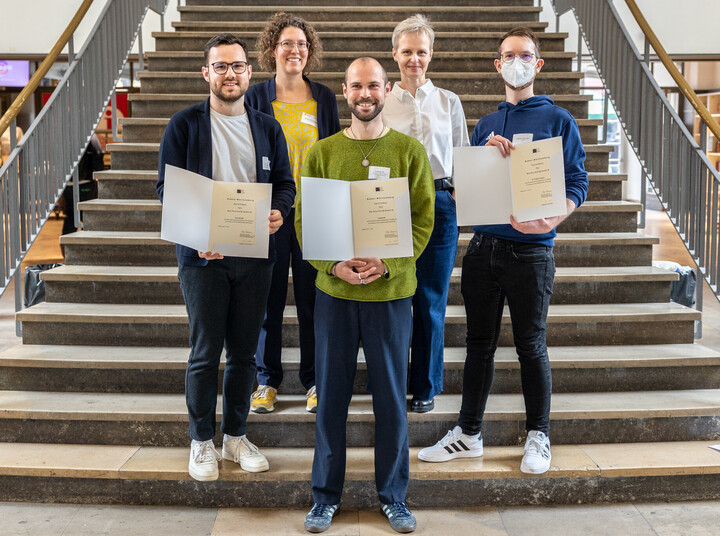 Gruppenfoto auf einer Treppe: Mehrere Personen, die ein HDZ-Zertifikat erhalten haben, stehen gemeinsam mit der Fachbereichsleitung und der Prorektorin in gestaffelter Anordnung. Alle lächeln und halten ihre Zertifikate sichtbar in den Händen.
