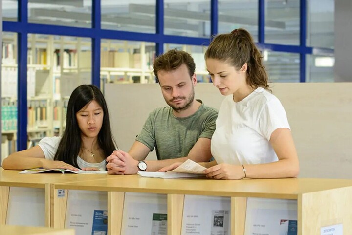 3 Stundenten in der Bibliothek