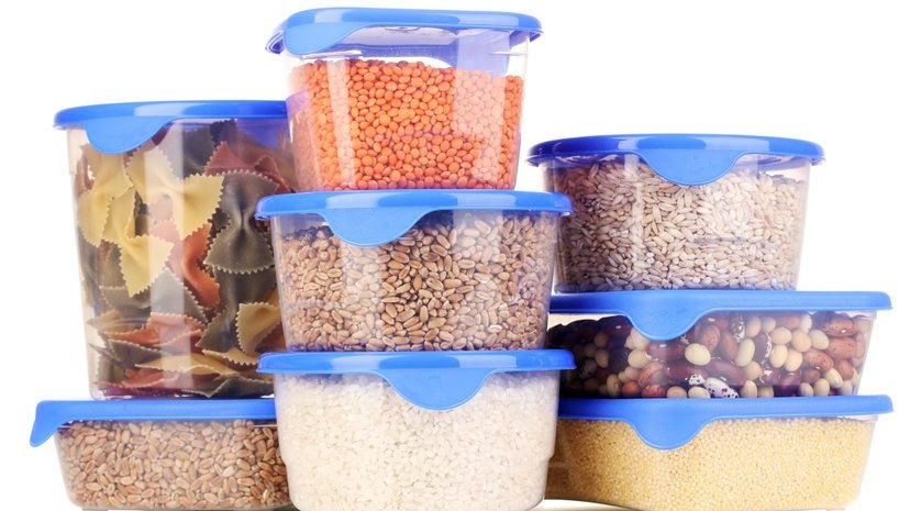 Tupperware-Dosen sind mit verschiedenen Lebensmittel wie Nudeln oder Linsen befüllt.