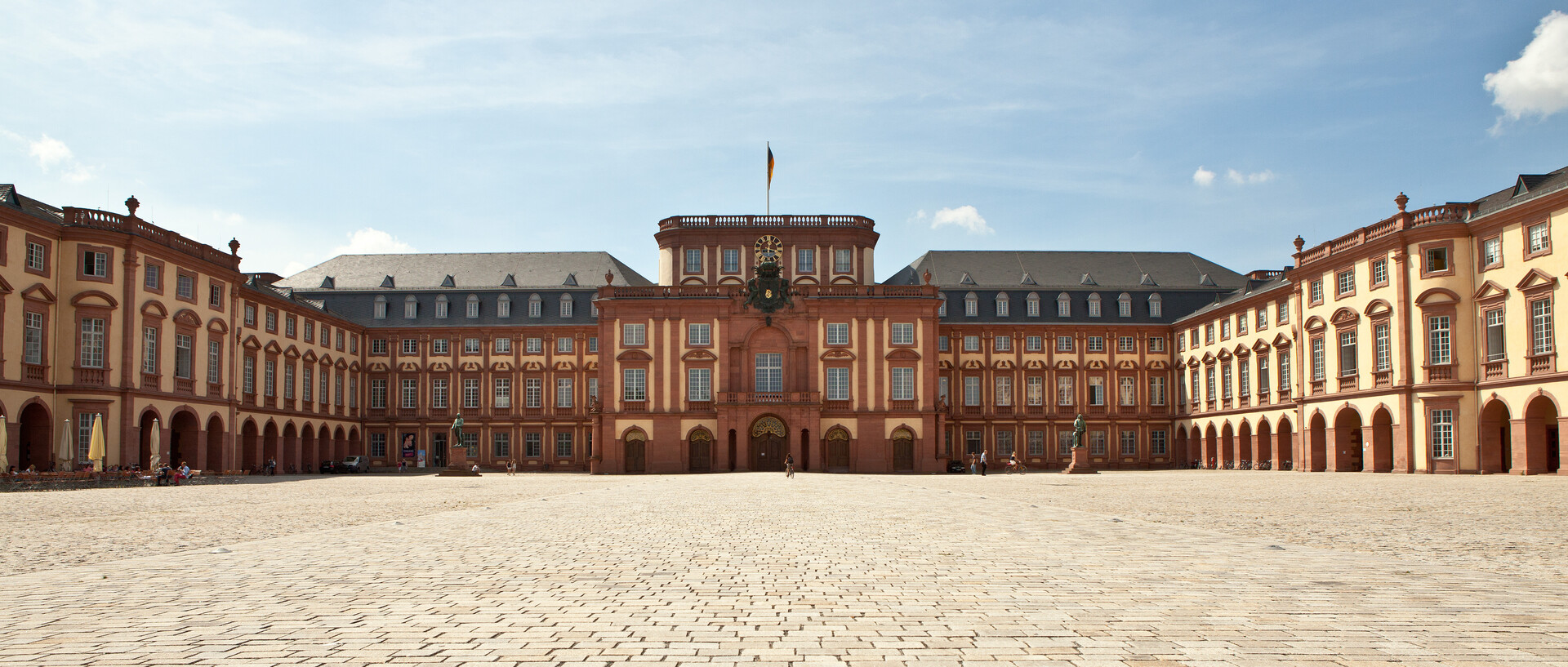 Das Mannheimer Barockschloss und der Ehrenhof unter blauem Himmel.