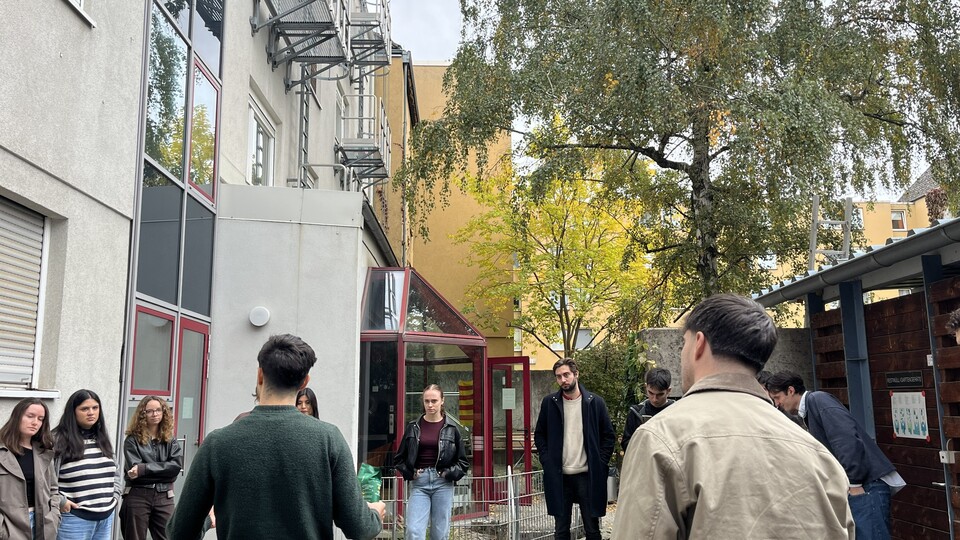 Teilnehmende im Innenhof des IBZ der Uni Mannheim bei der Zubereitung einer Paella 