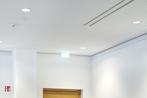 Vier Teilnehmende blicken fröhlich und interessiert zu einer Person außerhalb des Bildes und sitzen gemeinsam um einen Tisch herum.