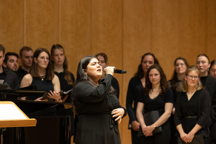 Eine Frau singt in ein Mikrofon.