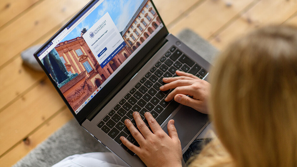 Eine Frau loggt sich auf ihrem Laptop bei einer Webseite ein.