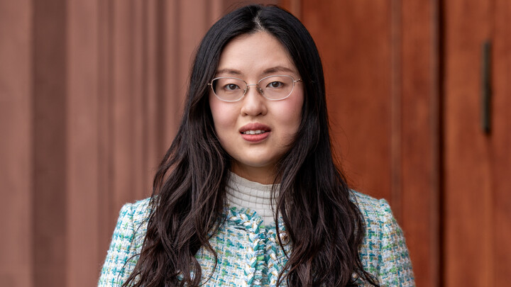 Portrait of Yin Yiwei. She is wearing a green/blue/white checked jacket and is standing in front of a door of Mannheim Palace.