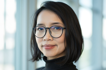 Portrait von Eirliani Rahman. Sie trägt einen schwarzen Bob und eine Brille. 