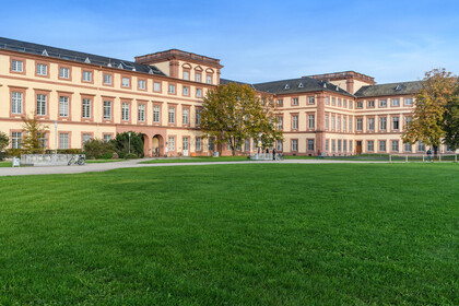 Schloss der Uni Mannheim mit Rasenfläche im Vordergrund.