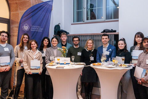 Ein Dutzend Menschen stehen nebeneinander und posieren für ein Foto.