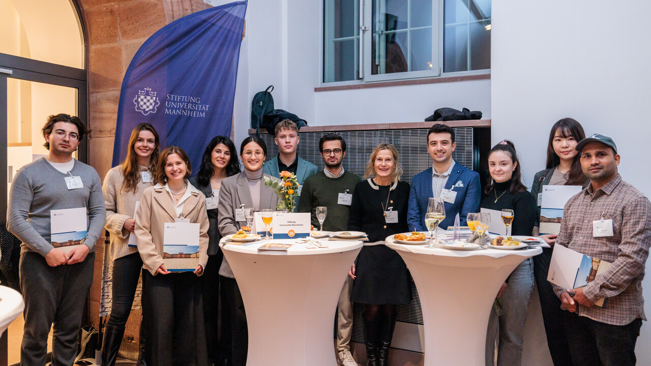 Ein Dutzend Menschen stehen nebeneinander und posieren für ein Foto.