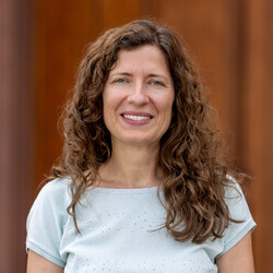 Katrin Menzel lächelt, hat braune, lockige, Haare