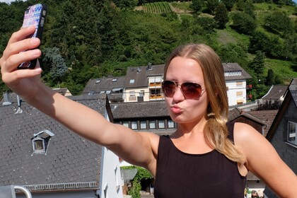Eine Frau macht ein Selfie auf der Dachterasse.