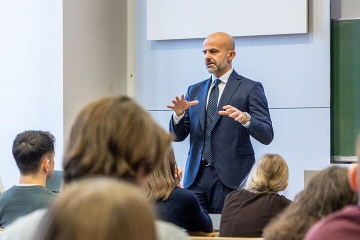 Foto in gut besuchtem Hörsaal mit Blick auf Vortragenden