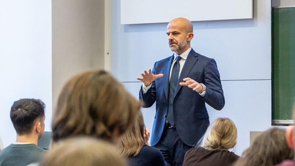 Foto in gut besuchtem Hörsaal mit Blick auf Vortragenden