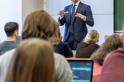 Foto in gut besuchtem Hörsaal mit Blick auf Vortragenden