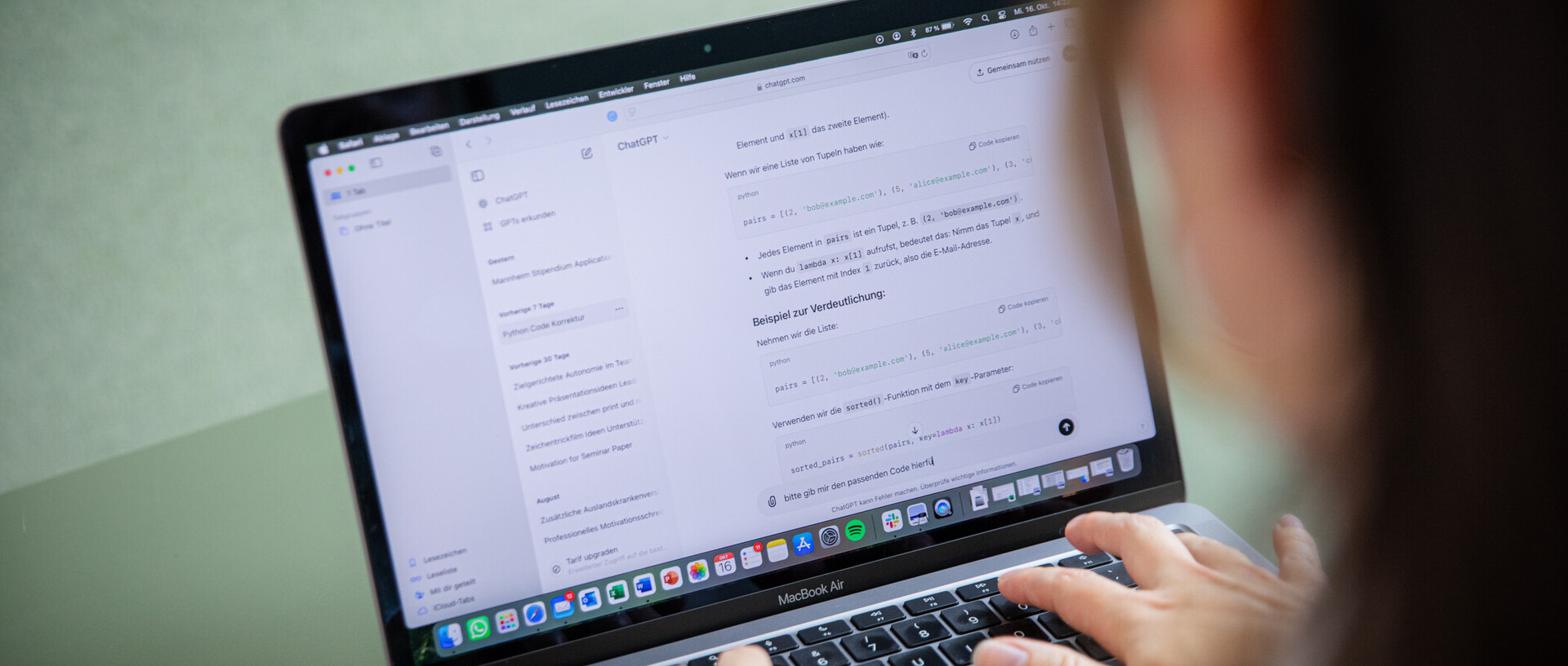 Eine Person ist von hinten zu sehen, wie sie am Laptop arbeiten und ChatGPT zum Arbeiten nutzt.