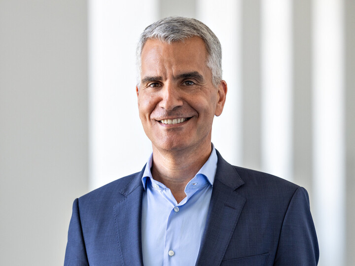 Prof. Dr. Thomas Fetzer trägt ein dunkelsblaues Sakko und ein hellblaues Hemd. Er hat kurzes graues Haar und lächelt. 