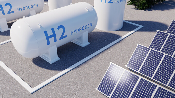White hydrogen tanks with the inscription 'H2 Hydrogen' stand next to solar panels on an asphalt floor.
