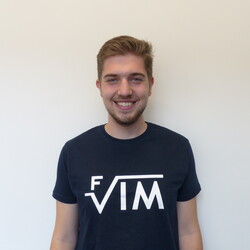 Tim trägt ein T-Shirt der Fachschaft für Informatik und Mathematik. Er lächelt freundlich in die Kamera.