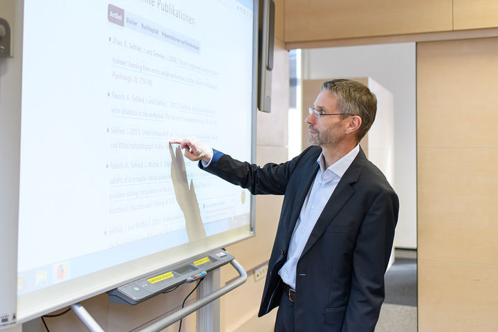Mann bedient digitales Whiteboard 