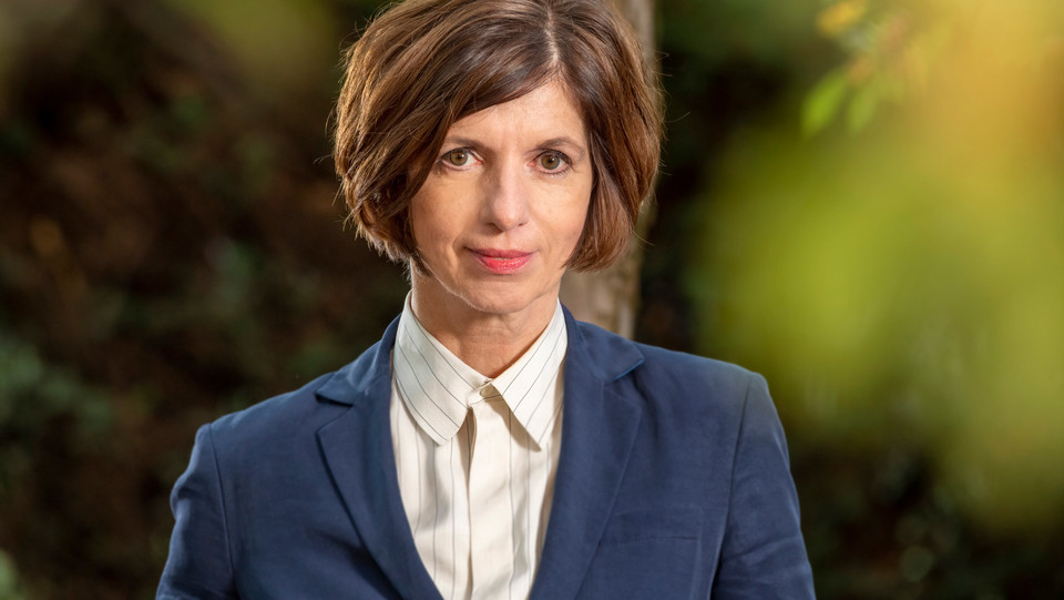 Portrait von Jutta Allmendinger. Sie trägt einen blauen Blazer über einer weißen Bluse. 
