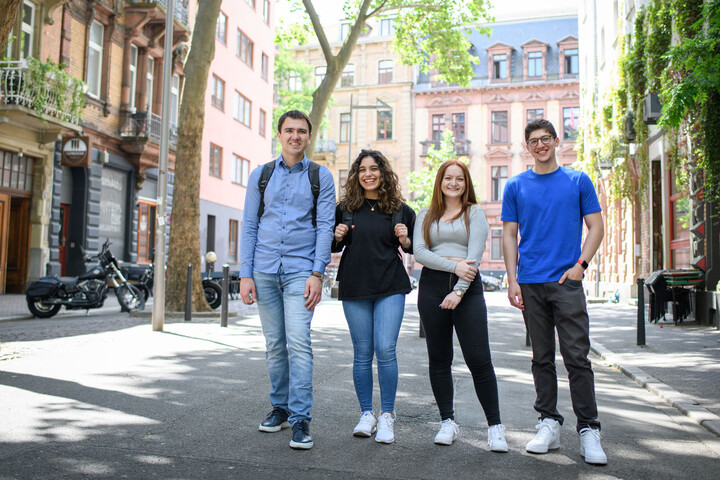 Vier lachende Studierende auf einer verkehrsberuhigten Straße im Mannheimer Jungbusch