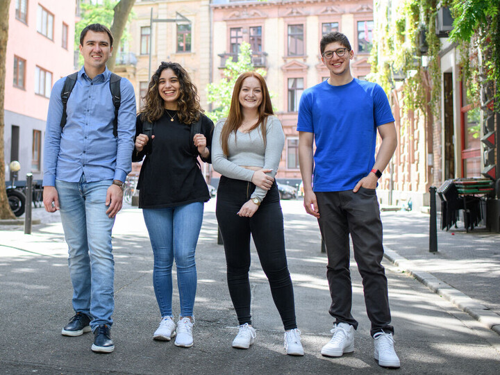 Vier lachende Studierende auf einer verkehrsberuhigten Straße im Mannheimer Jungbusch