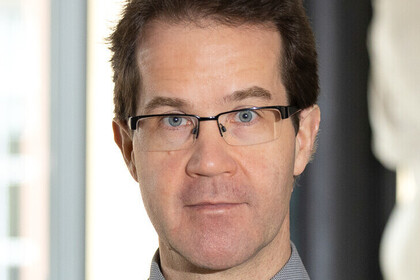Portrait von Christian Mann. Er trägt eine Brille mit schwarzem Rahmen.