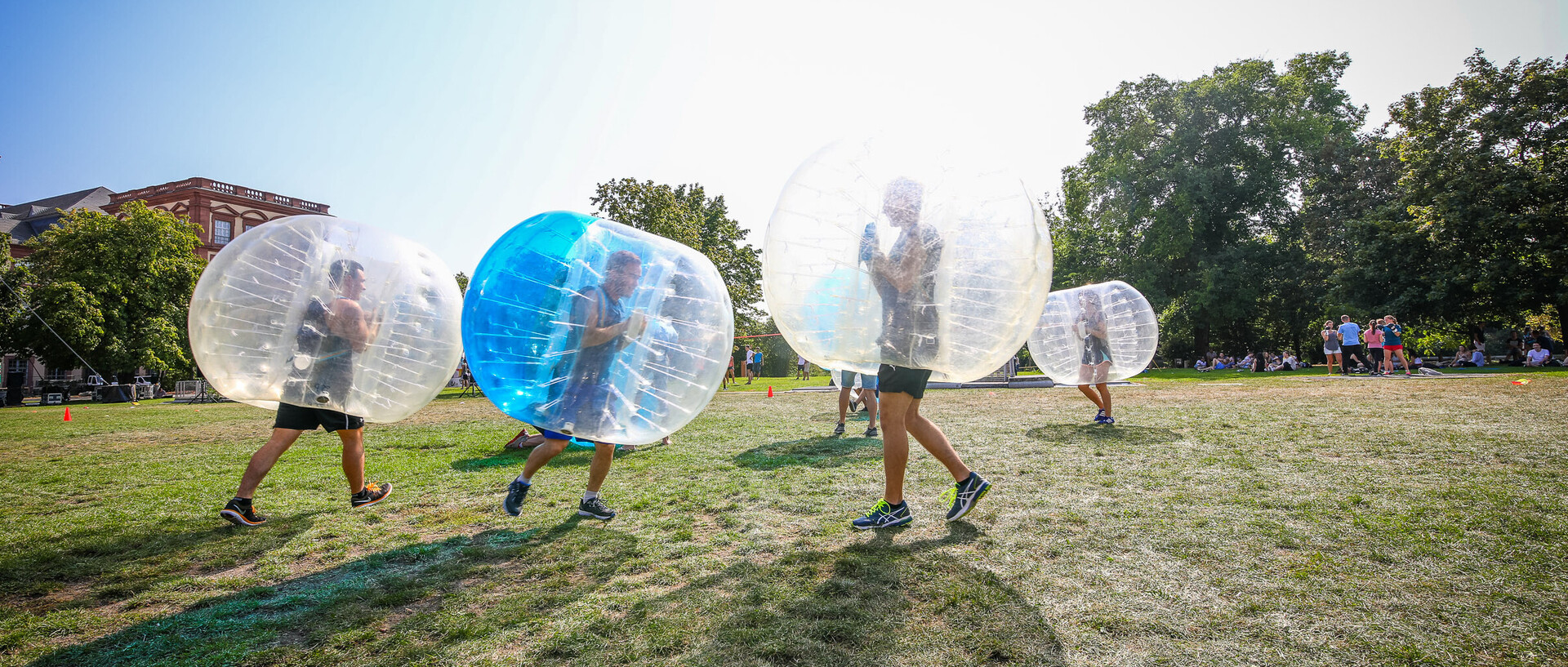 Sportler spielen Bubble-Fußball auf einer Wiese