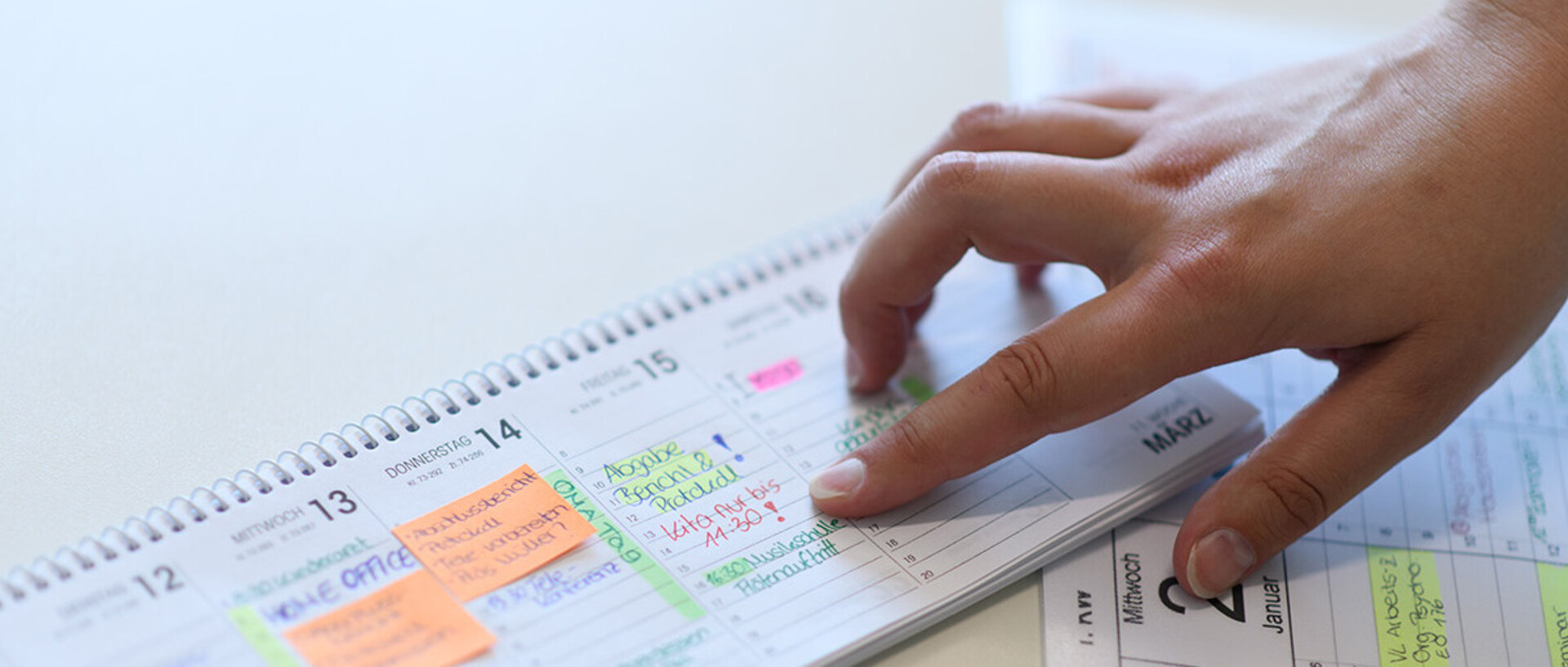 Hand zeigt auf einen Tag im Kalender.