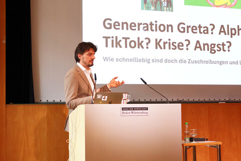 Dr. Frederick de Moll hält eine Keynote und spricht hinter einem Rednerpult.