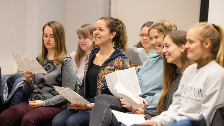 Lachende Studierende bei einer Chorprobe