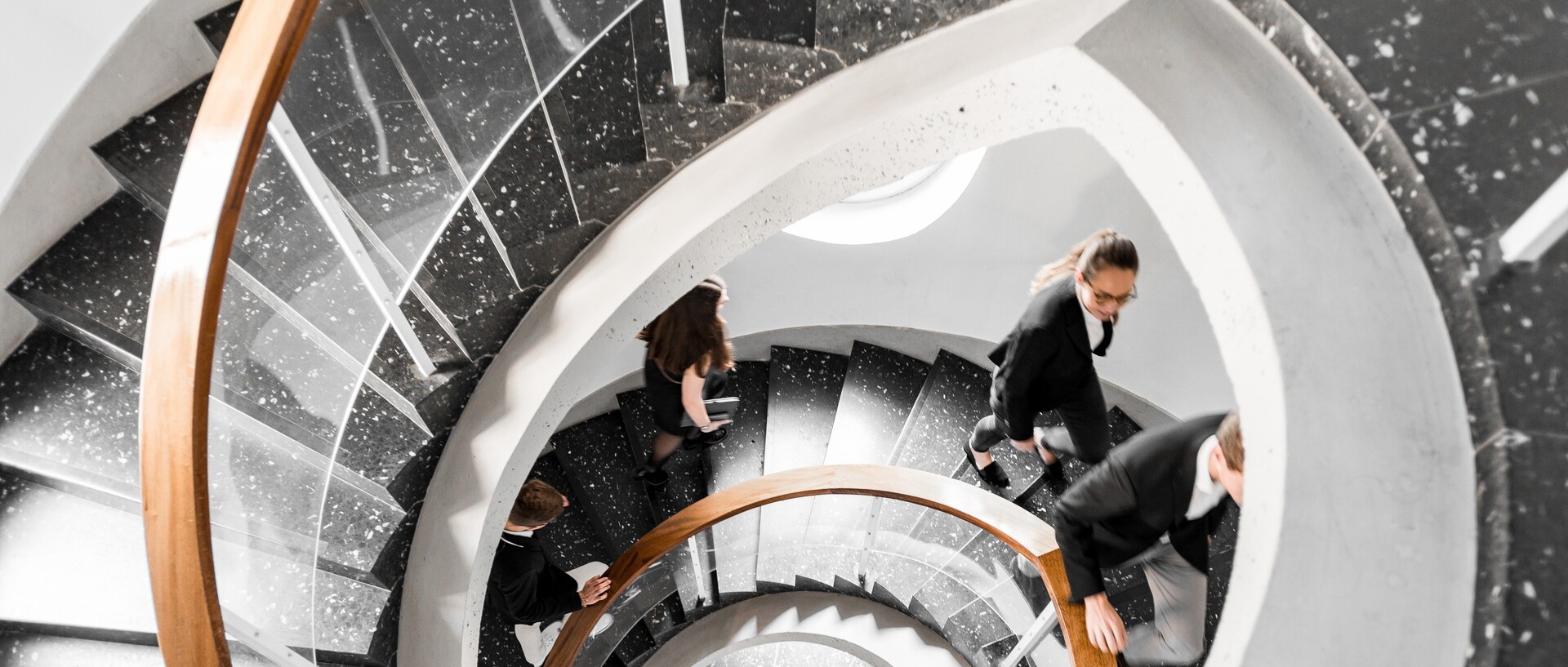 Bird's eye view of a black spiral staircase. Students walk up the stairs. Link: Career prospects