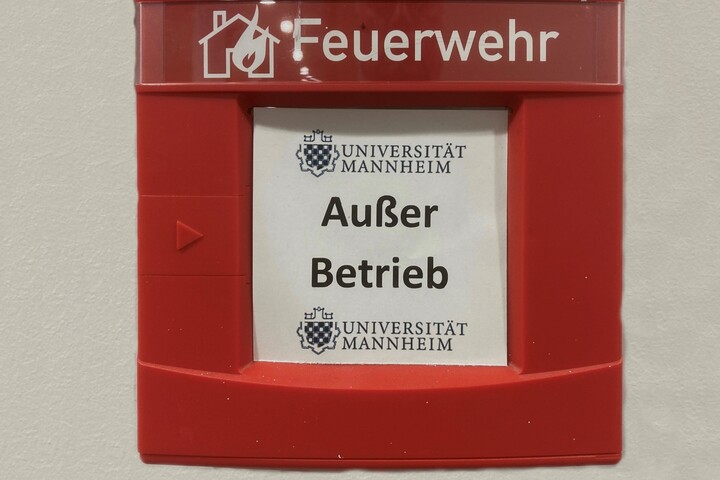 Roter Wandkasten mit der Aufschrift "Feuerwehr" und dem Logo der Uni Mannheim und "Außer Betrieb"