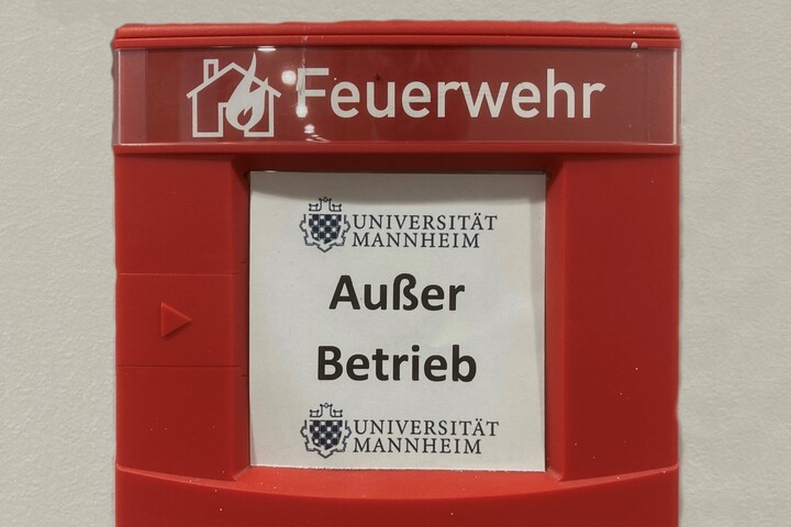Roter Wandkasten mit der Aufschrift "Feuerwehr" und dem Logo der Uni Mannheim und "Außer Betrieb" 