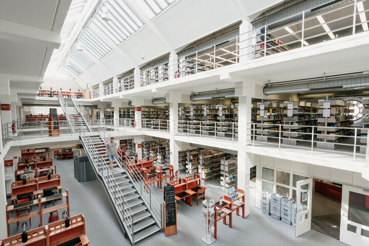 Bibliotheksbereich A3: Großzügige, helle Bibliothek mit Treppe in der Mitte