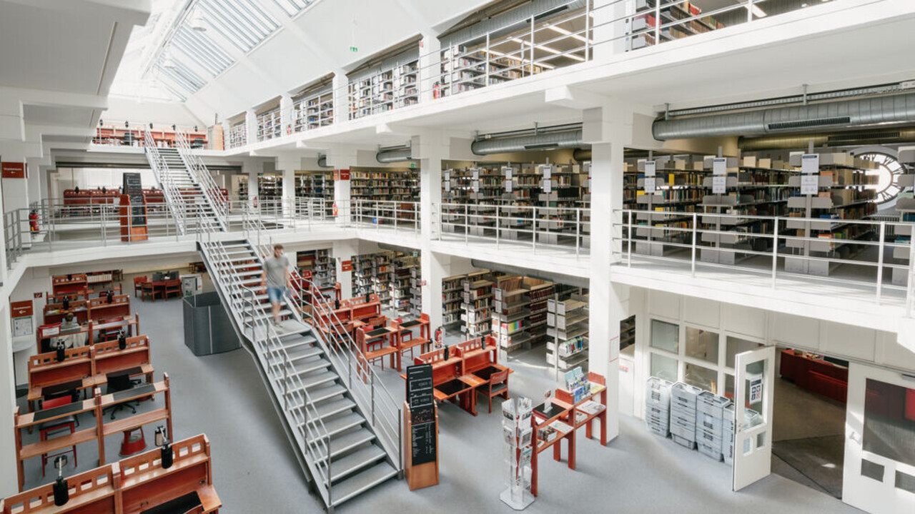 Bibliotheksbereich A3: Großzügige, helle Bibliothek mit Treppe in der Mitte